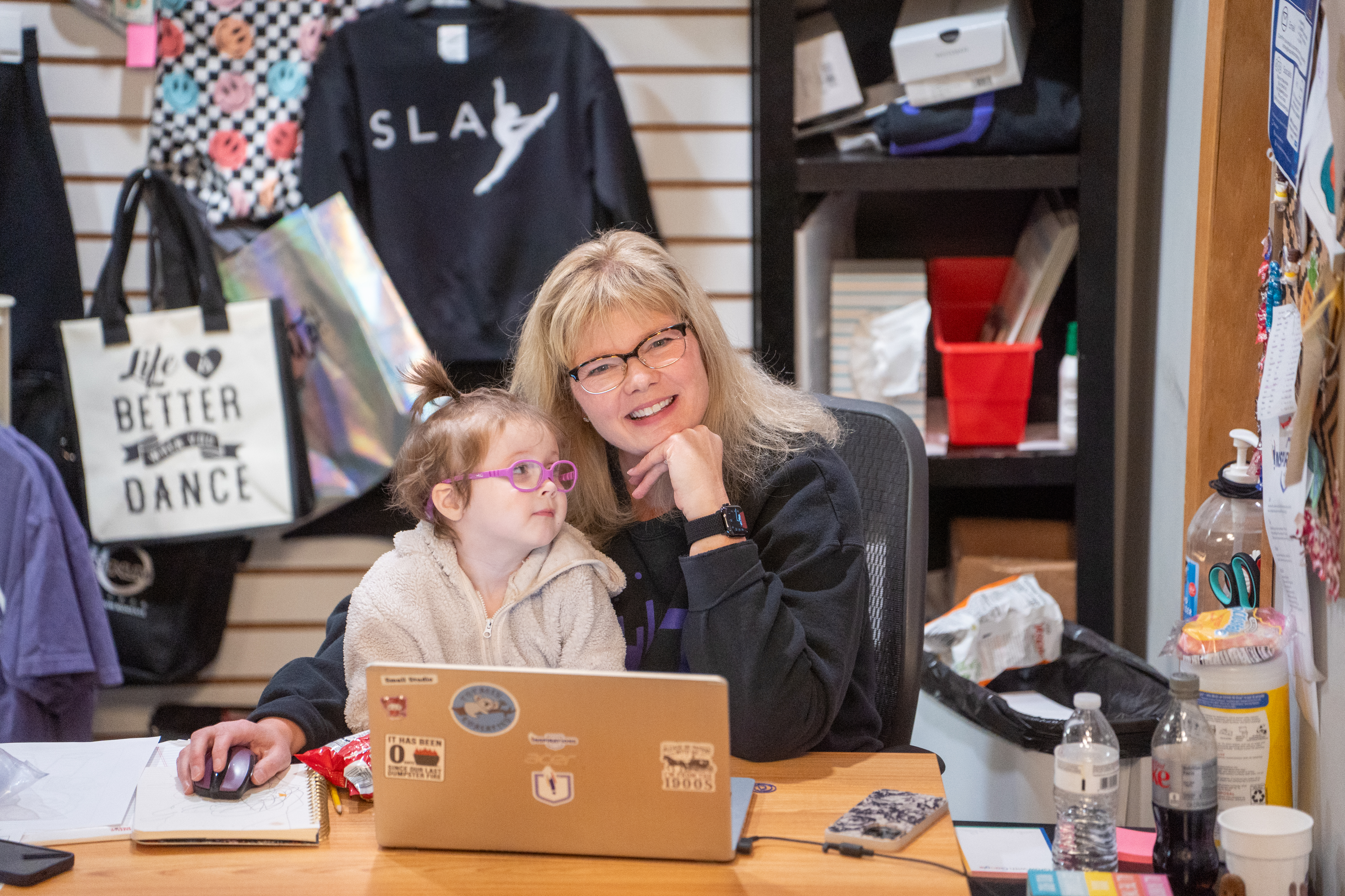 A member of the Inspirations Academy front desk team with a young student at the office desk
