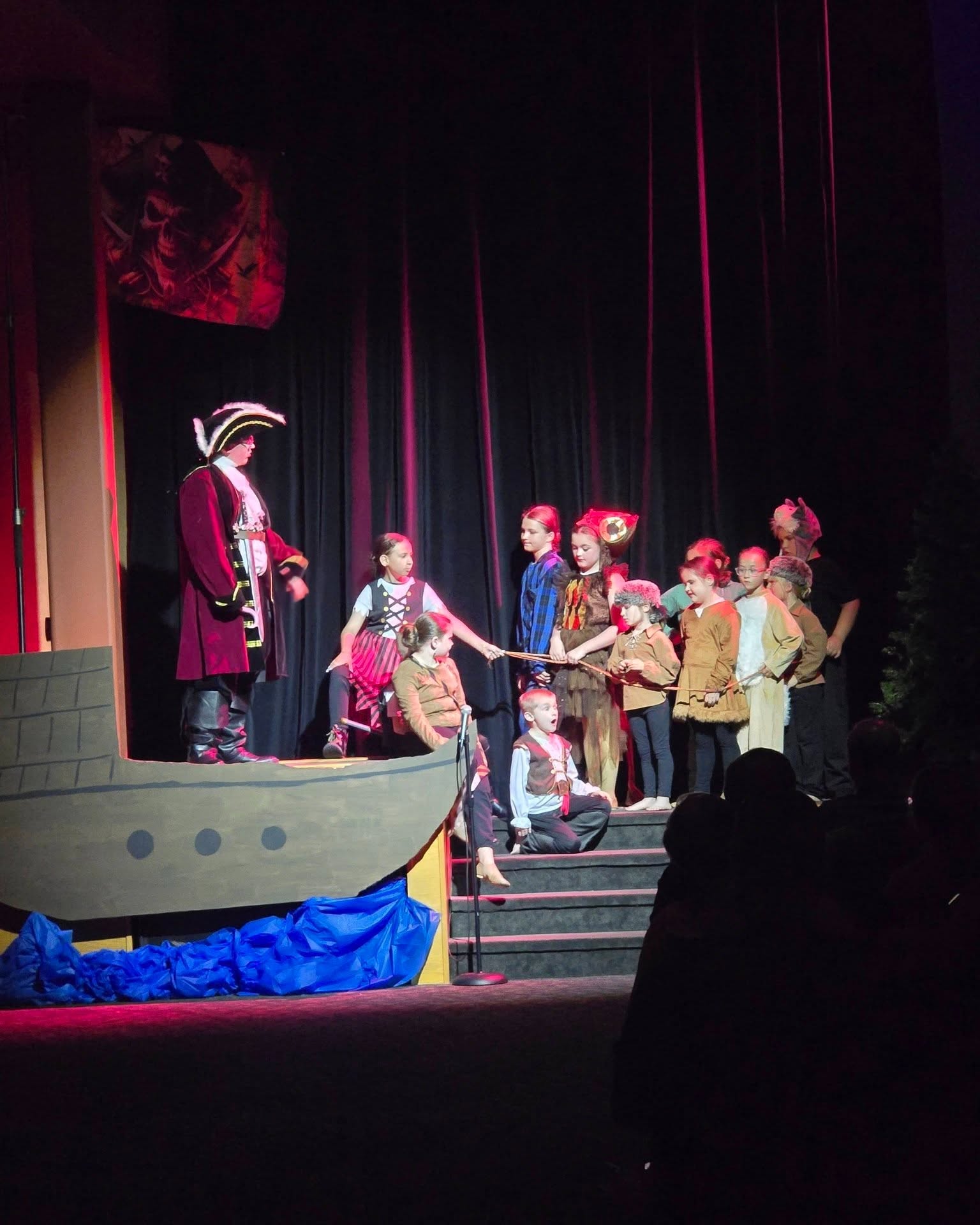 The cast performing a scene on stage during a past Inspirations Fine Arts Academy production