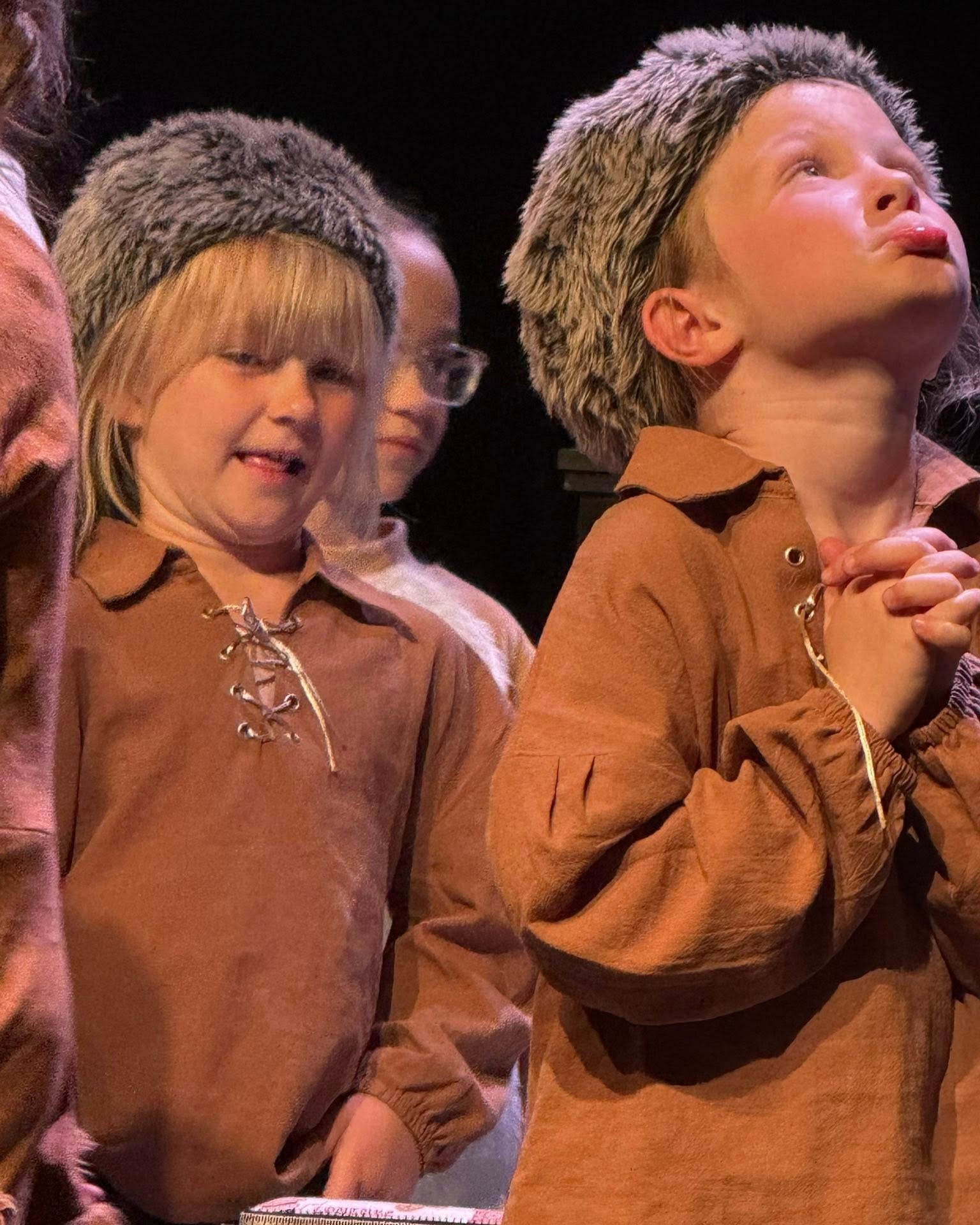 Two young actors in costume on stage during a past Inspirations Fine Arts Academy production