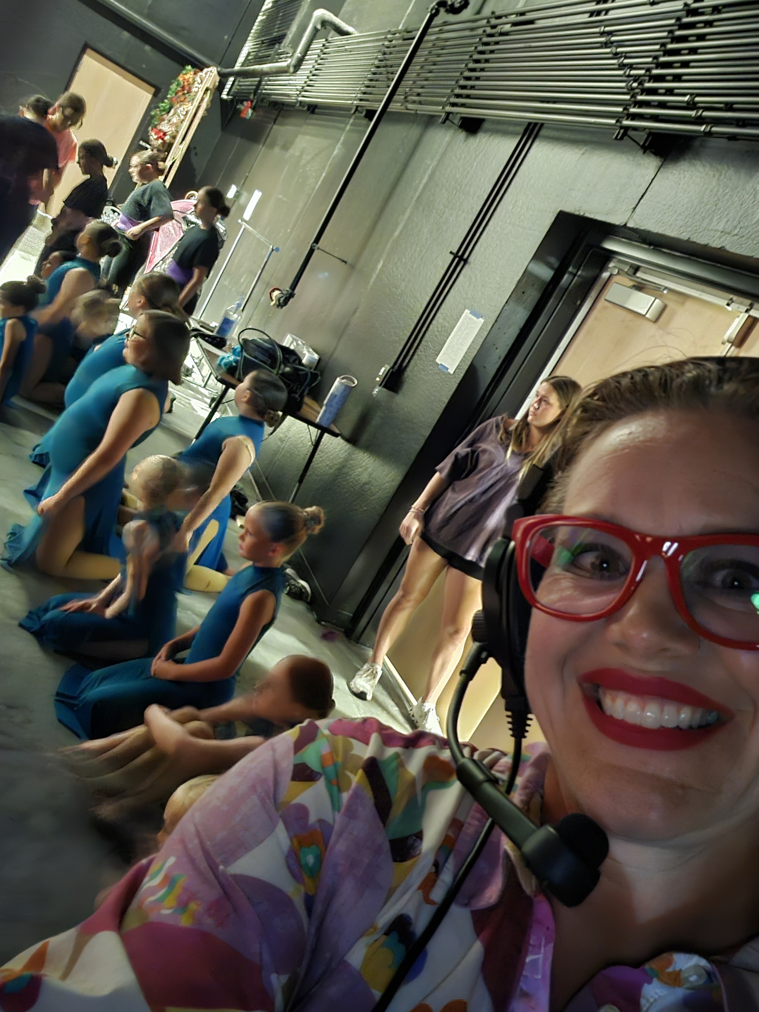 A staff member with dancers and crew backstage before taking the stage