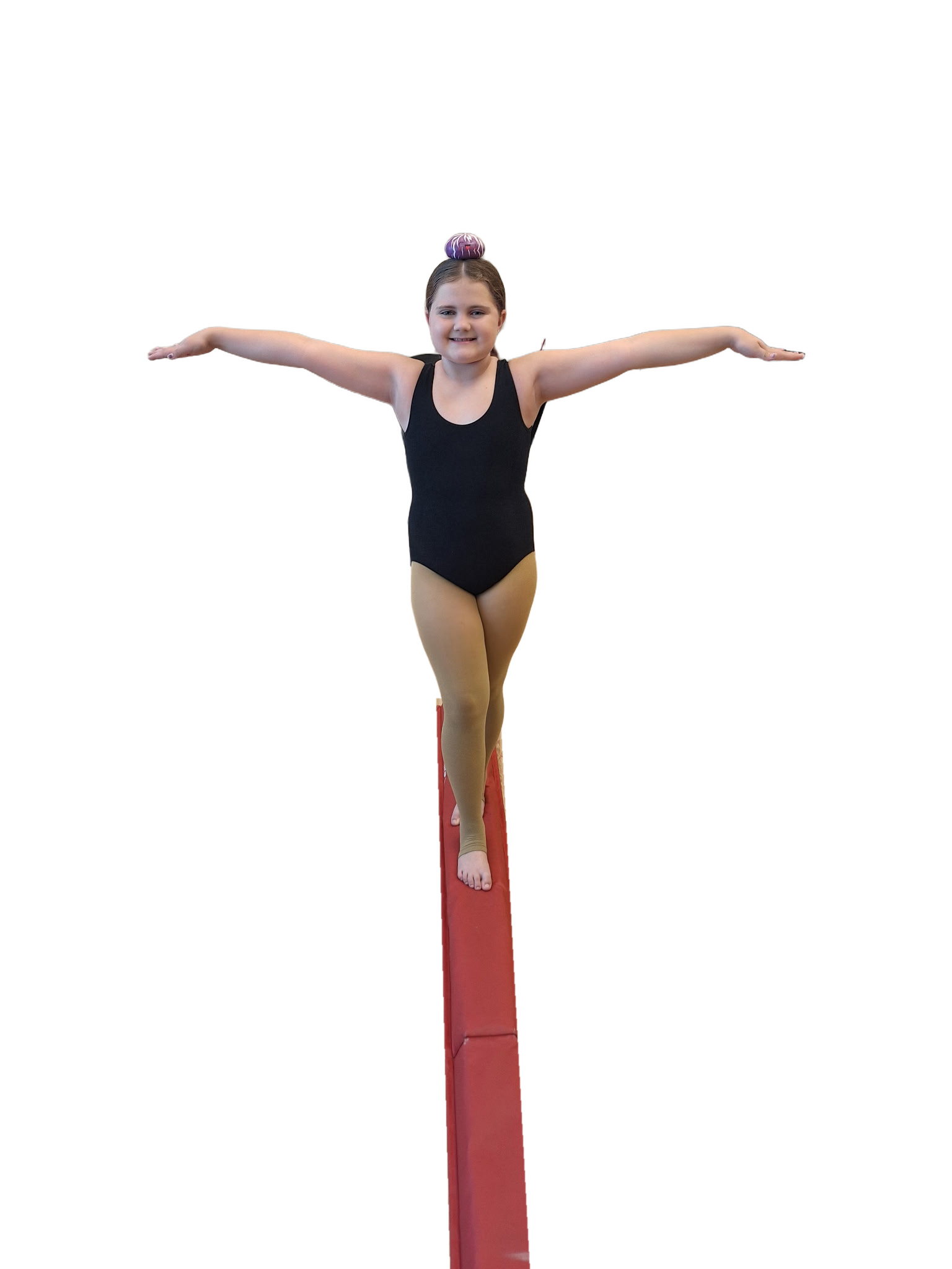 A student balancing the Dancing With Dumplings plush toy on her head on the balance beam.