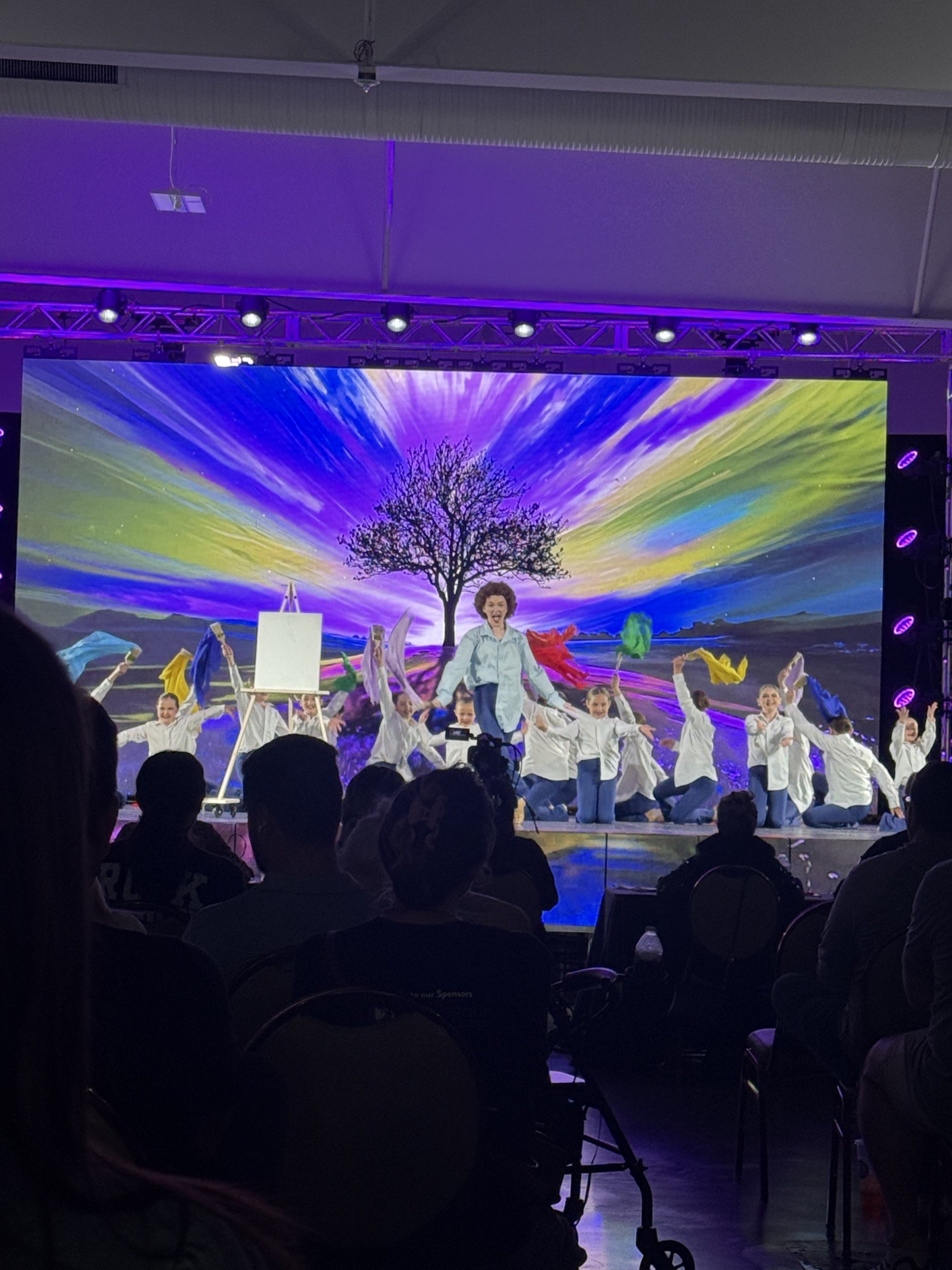 Inspirations Academy dancers performing an art themed number on stage at a dance competition.