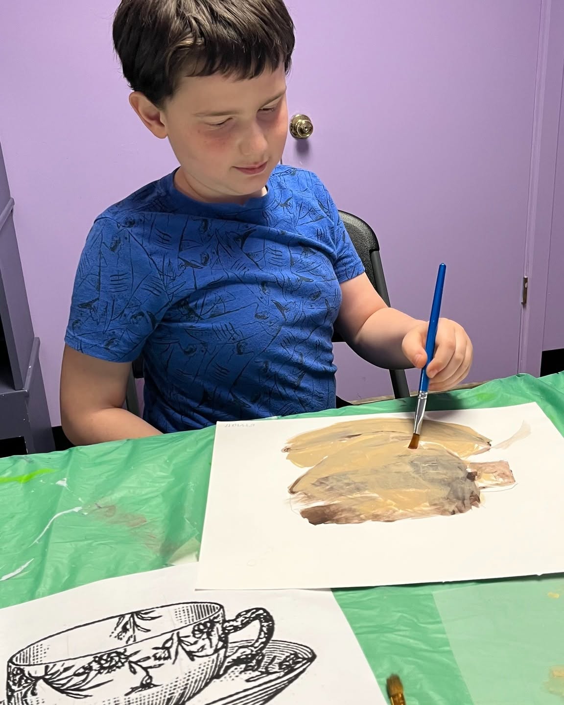 A student mixing paint colors during Inspirations Academy art class