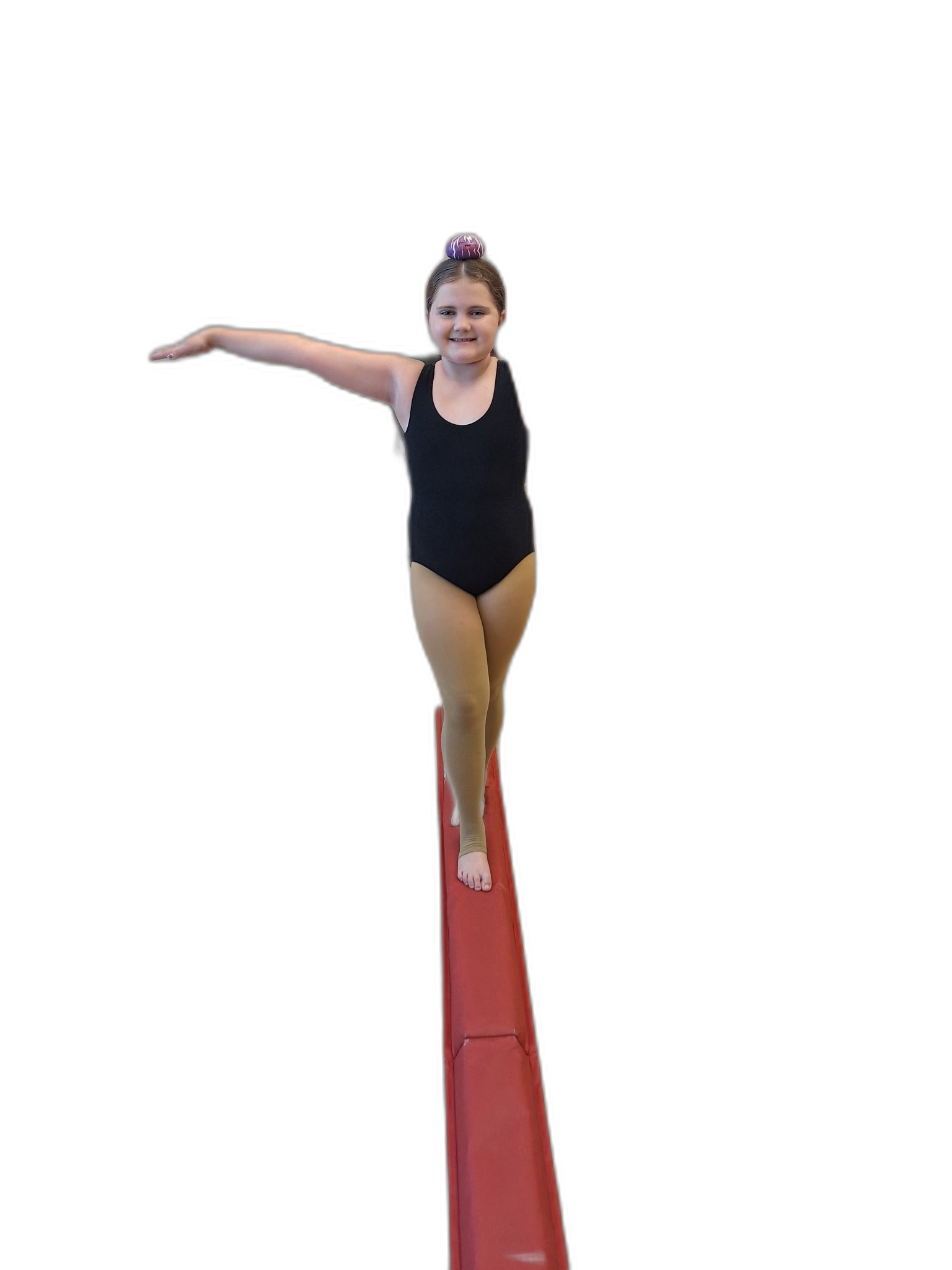 A student balancing the Dancing With Dumplings plush toy on her head on the balance beam.