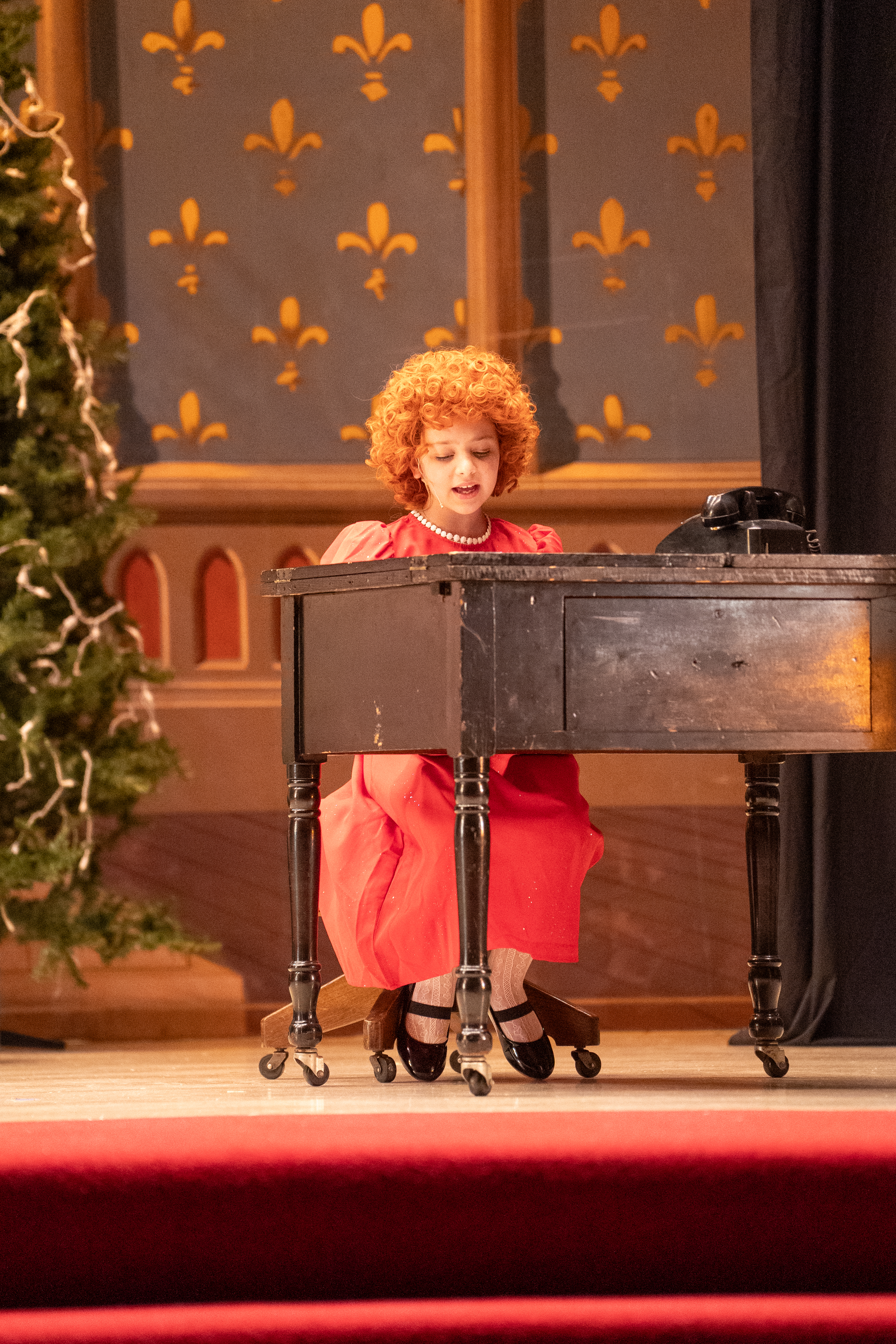 A young performer in costume on stage during a past Inspirations Fine Arts Academy production