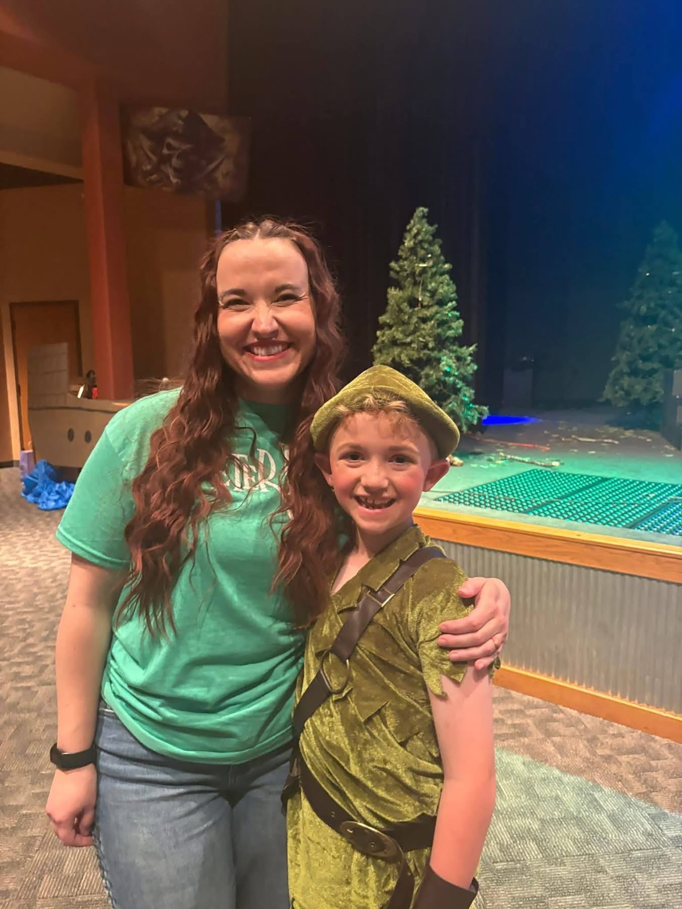 An Inspirations Fine Arts Academy staff member with a young cast member backstage during a past production