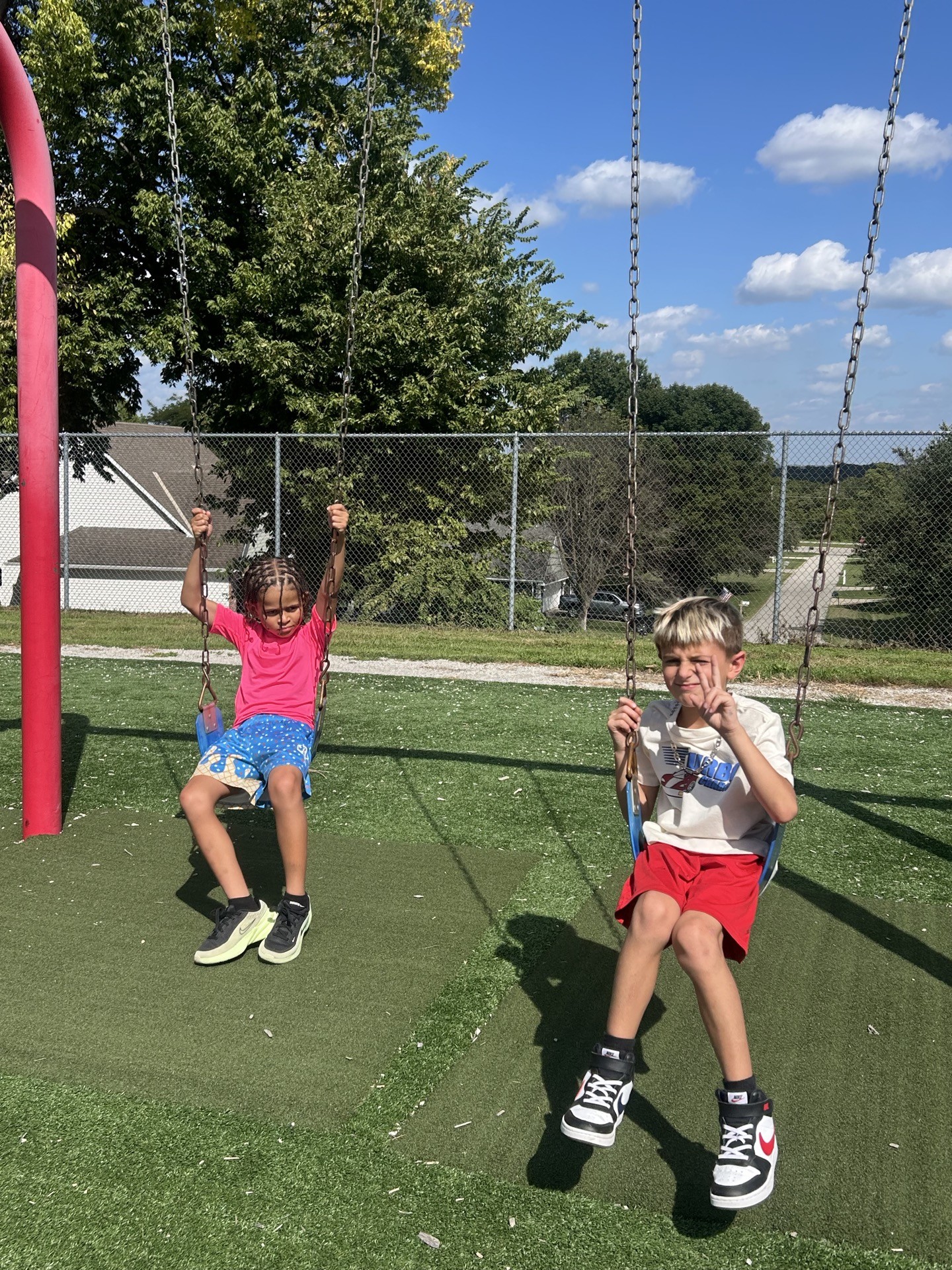 Two children playing on swings outside during Inspirations Academy after school care